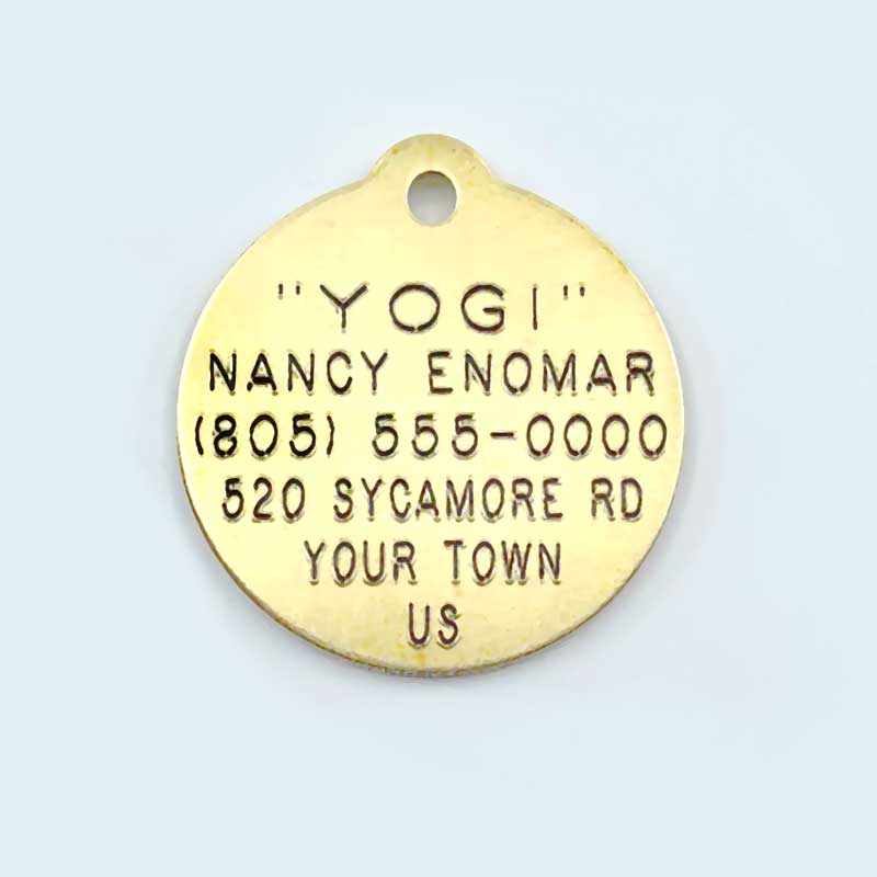 round brass tag with six lines of text engraved